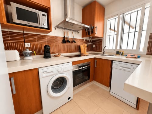 Cocina moderna del apartamento Aroma de Poniente en Living Sur, Sanlúcar de Barrameda, con muebles de madera y acero inoxidable