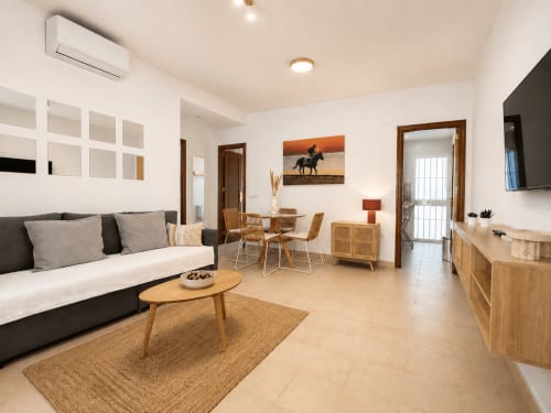 Moderna sala de estar en Living Sur, Sanlúcar de Barrameda con sofá, mesa de comedor, muebles de madera y terraza
