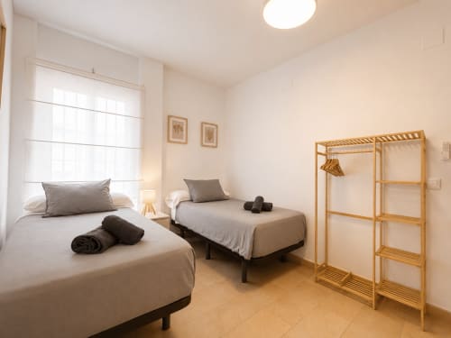 Dormitorio doble con armario de madera en el apartamento Living Sur, Sanlúcar de Barrameda