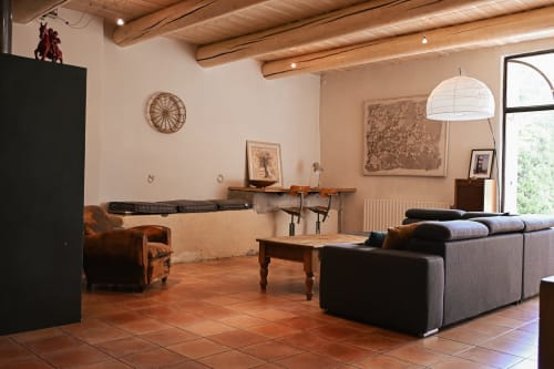 Salon rustique du Mas De La Digue B&B à Châteaurenard avec carrelage en terre cuite, poutres en bois et mobilier chaleureux