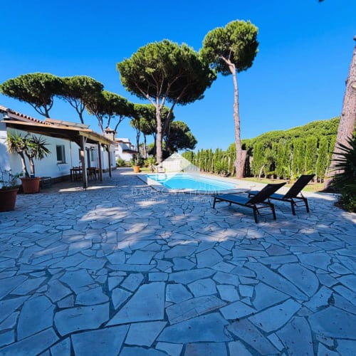 Villa Barrosa en Chiclana con piscina privada, tumbonas y jardines bien cuidados bajo cielo azul