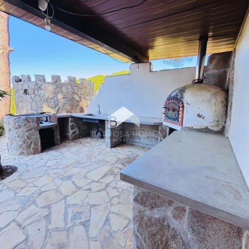 Terraza de Villa Irlanda con patio de piedra, barbacoa integrada y vistas a la piscina en Chiclana de la Frontera