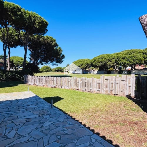 Jardín privado con patio en Villa Irlanda, Barrosa Home en Chiclana de la Frontera, con cerca de madera y jardines cuidados