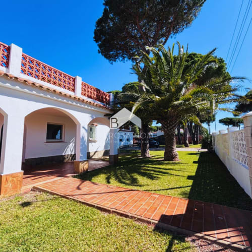 Villa Irlanda en Barrosa Home, Chiclana de la Frontera, destaca por su arquitectura blanca con arcos, patio de terracota y palmeras