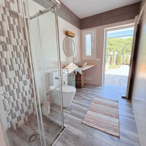 Baño moderno en Villa Irlanda con ducha abierta, lavabo tipo recipiente y vistas al jardín en Barrosa Home, Chiclana de la Frontera