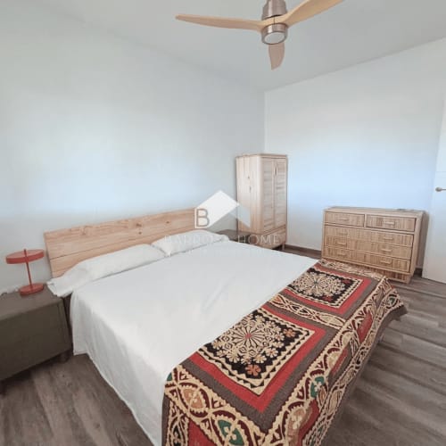 Luminoso dormitorio en Villa Irlanda de Barrosa Home con cama de madera, ropa de cama blanca y textil tradicional en Chiclana de la