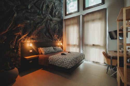 Camera moderna all'hotel Oltre Exclusive di Palermo con parete nera d'impatto, biancheria a motivi, illuminazione calda