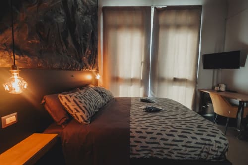 Camera doppia deluxe esclusiva Oltre a Palermo con accenti arancioni, biancheria geometrica moderna, illuminazione a sospensione e vista sulla città