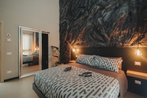 Camera d'albergo moderna a Palermo con biancheria a motivi, murale artistico nero, lampade a sospensione e armadio con porta specchiata