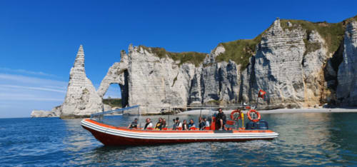 Red and white boat at Étretat's white cliffs near Clos Céleste, Normandy France