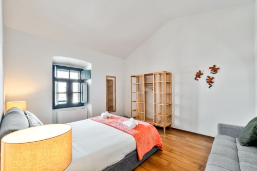 Quarto moderno e luminoso na villa Casa do Loureiro em Alandroal com móveis de madeira, roupas de cama brancas e espaço aconchegante