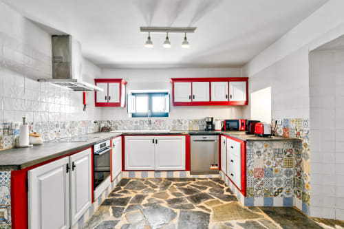 Cozinha moderna da villa Casa do Loureiro em Alandroal com armários vermelho e branco, backsplash de azulejos coloridos