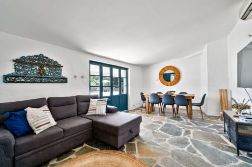 Sala de estar e jantar em open plan moderna na Casa do Loureiro, Alandroal, com sofá escuro, mesa de madeira e piscina