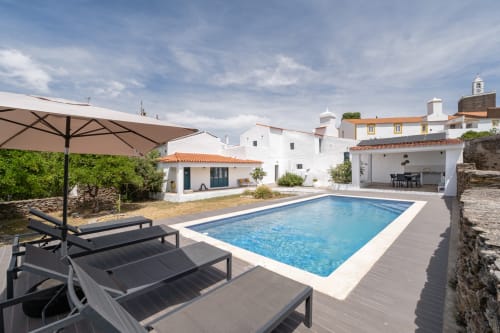 Vila de luxo Casa do Loureiro em Alandroal com piscina retangular, espreguiçadeiras, guarda-sol e edifícios brancos