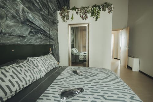 Camera moderna di Oltre Exclusive a Palermo con biancheria geometrica, testata scura e vista del bagno in camera