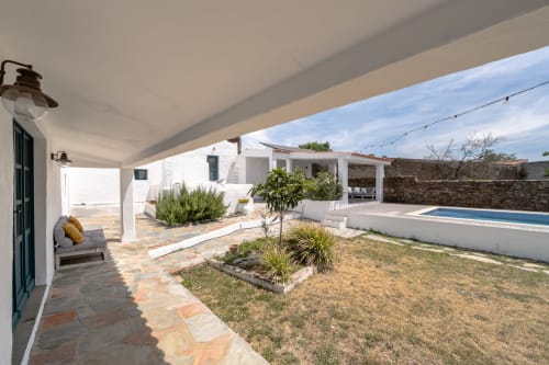 Villa Casa do Loureiro em Alandroal com pátio à beira da piscina, arquitetura caiada e jardins bem cuidados sob pérgola