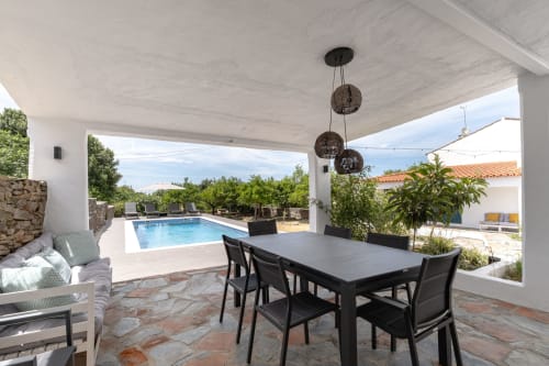 Pátio coberto com mesa de jantar com vista para a piscina na villa Casa do Loureiro em Alandroal