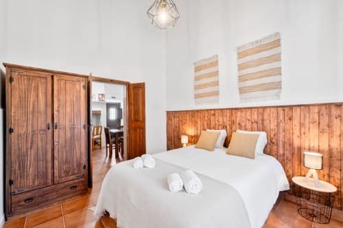 Quarto luminoso na Casa do Ti Filipe com camas de solteiro, cabeceira em madeira, teto com vigas rústicas e decoração portuguesa