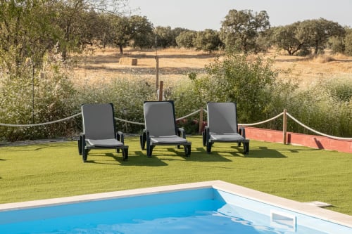 Três espreguiçadeiras no gramado verde com vista para a zona rural na Casa do Ti Filipe, apartamento Airbnb MontesJuntos com piscina