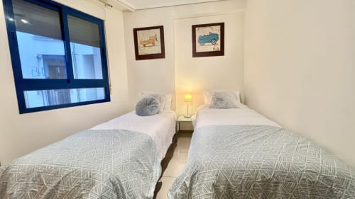 Habitación doble en apartamento con vista al mar en Valencia de Pataconablue Rentals con decoración moderna y arte vintage de coches