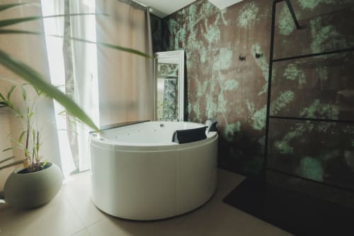 Bagno moderno con vasca indipendente bianca, carta da parati botanica, box doccia in vetro con cornice nera e pianta in vaso