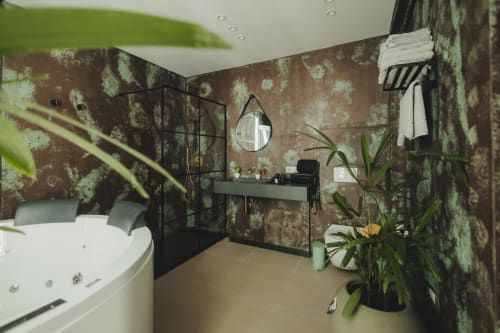 Lussuoso bagno dell'hotel Oltre Exclusive a Palermo con vasca freestanding, specchio rotondo, vanity, piante in vaso e
