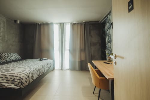 Suite deluxe spaziosa presso Oltre Exclusive a Palermo con letto a motivo geometrico, scrivania in legno e vista sul cortile