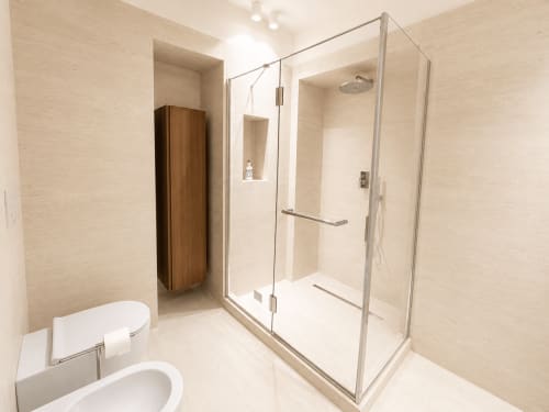 Bagno moderno della Suite Ingrid presso Seven Suites Sanremo con doccia in vetro, wc e pavimentazione in piastrelle beige.