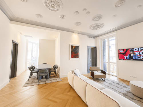 Suite Ingrid alle SEVEN SUITES SANREMO con divano color crema, parquet, soffitto decorativo e vista sulla città