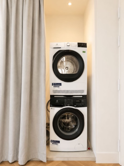 Lavatrice e asciugatrice Electrolux bianche impilate nell'area lavanderia Suite Ingrid dell'hotel-aparthotel SEVEN SUITES SANREMO