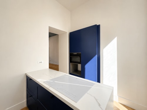 Cucina moderna con top in marmo, armadi blu navy e elettrodomestici integrati nell'appartamento SEVEN SUITES SANREMO