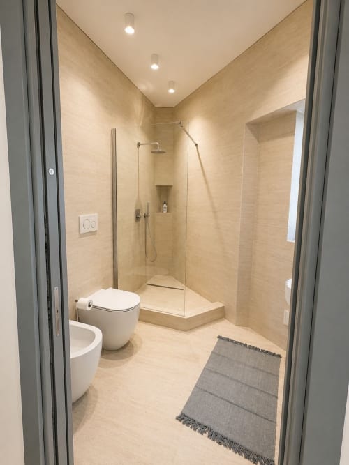 Bagno moderno della Suite Ingrid presso Seven Suites Sanremo con toilet, doccia walk-in, piastrelle beige e scaldasalviette