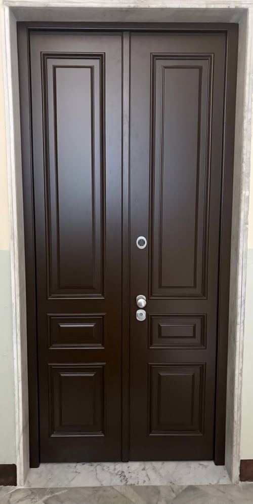 Doppie porte d'ingresso in legno scuro con pannelli decorativi alla Suite Ingrid, Seven Suites Sanremo