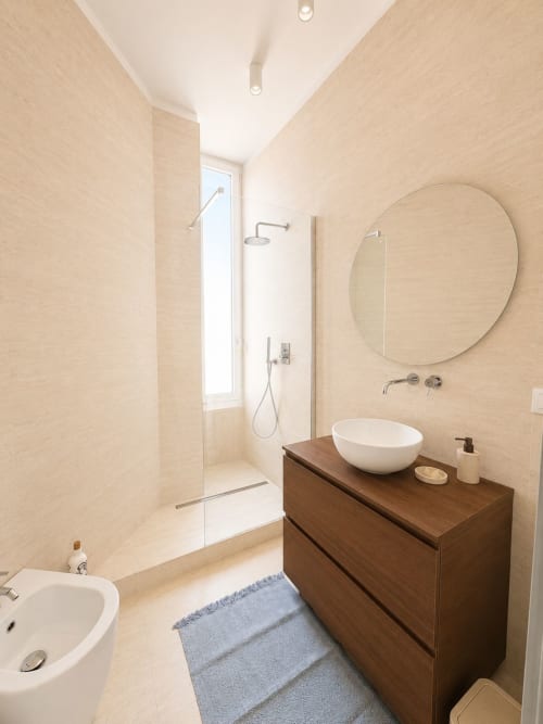 Bagno moderno nella Suite Ingrid di SEVEN SUITES SANREMO con specchio rotondo, lavabo a imbuto, mobile in legno e doccia walk-in