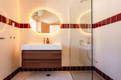 Modern bathroom at FC Housing Company, Abrantes with LED mirror, wooden vanity, white tiles, and walk-in shower.