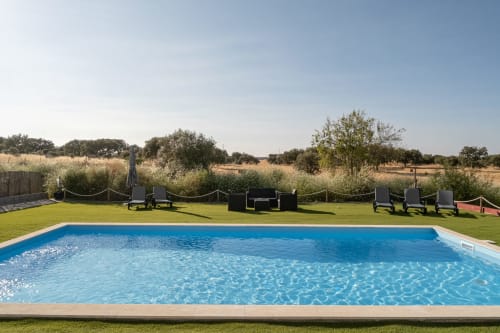 Piscina da Casa da Ritinha com espreguiçadeiras, jardim bem cuidado e vistas rústicas do interior de Montes Juntos