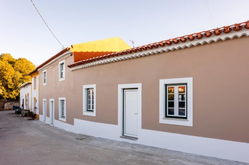 Encantador edifício de apartamentos bege e branco em Abrantes, Portugal com telhado de terracota e toldo amarelo