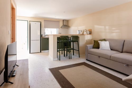 Apartamento T1 moderno no FC Housing em Abrantes com sala, cozinha, sofá cinzento e bancos altos pretos