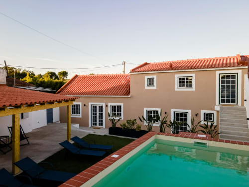 Apartamento da FC Housing em Abrantes com piscina turquesa, telhado em barro e vista para jardim interno