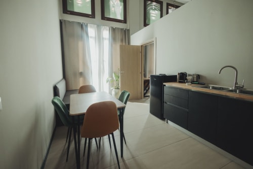 Lussuosa cucina moderna con arredamenti neri, piano in legno, tavolo da pranzo e vista sulla città