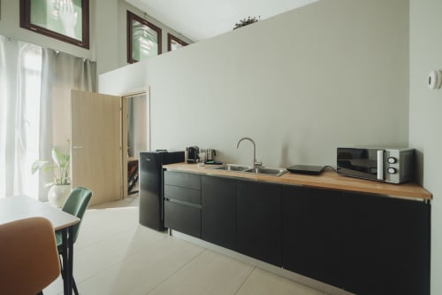 Moderna angolo cottura a Palermo B&B con mobili neri, piano in legno, lavello, microonde e caffettiera