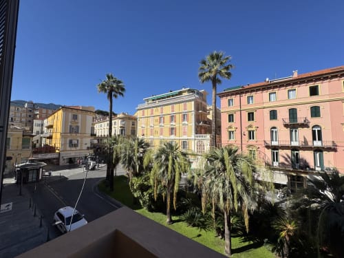 Edifici italiani colorati e palme con vista sulla piazza di Sanremo da Seven Suites Sanremo