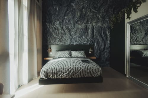 Camera da letto moderna nera con parete rivestita in texture, biancheria a motivi e vista sulla città presso Oltre Exclusive a Palermo
