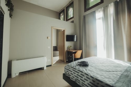 Camera moderna del B&B di Palermo con letto queen, scrivania, TV a schermo piatto e vista sulla città