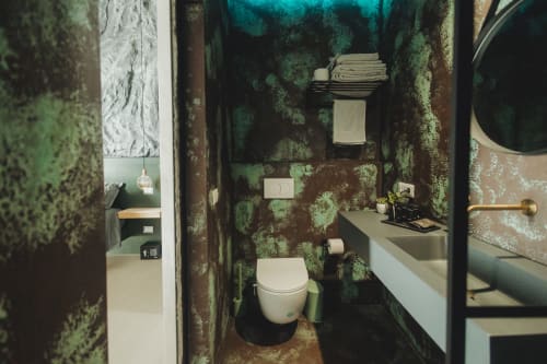 Bagno moderno all'Oltre Exclusive di Palermo con pareti a motivo muschio verde, wc bianco, lavabo e servizi