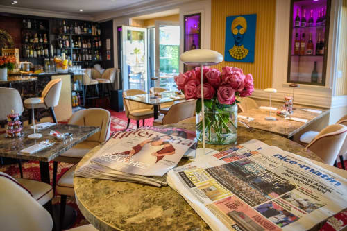 Élégant salon de l'Hôtel Splendide Cannes avec roses roses, lectures et mobilier raffiné vue sur la Méditerranée