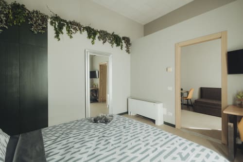 Camera da letto lussuosa moderna presso Oltre Exclusive a Palermo con tappeto geometrico, armadio nero e living open space