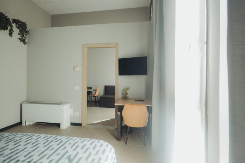 Camera da letto di lusso presso Oltre Exclusive a Palermo con scrivania, TV e vista sulla città
