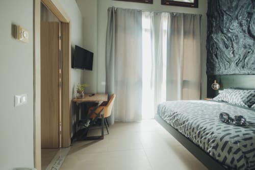 Camera moderna nell'appartamento Oltre Exclusive a Palermo con letto, scrivania, TV e vista città dalle porte finestre del balcone con tende