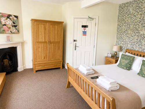 Superior Double Room at The Cornerhouse hotel in Somerset with wooden bed, wardrobe, fireplace and en-suite bathroom